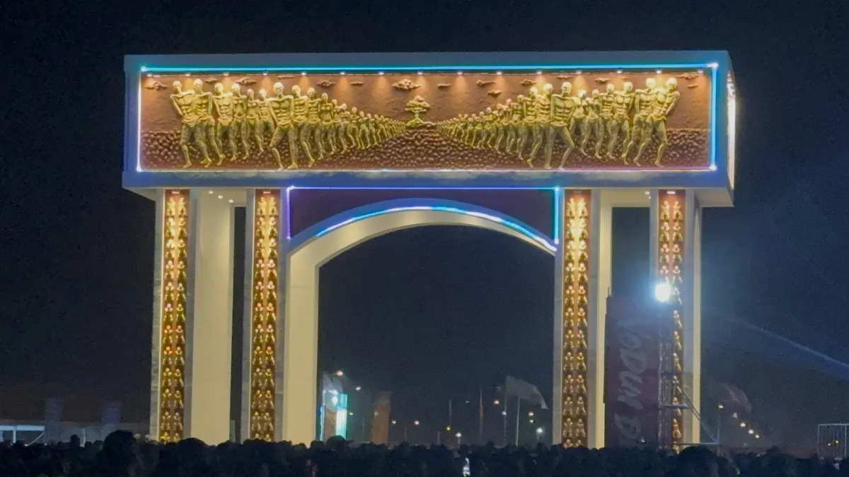 La Porte du Non-Retour illuminée de nuit pendant les Vodun Days, la foule au premier plan